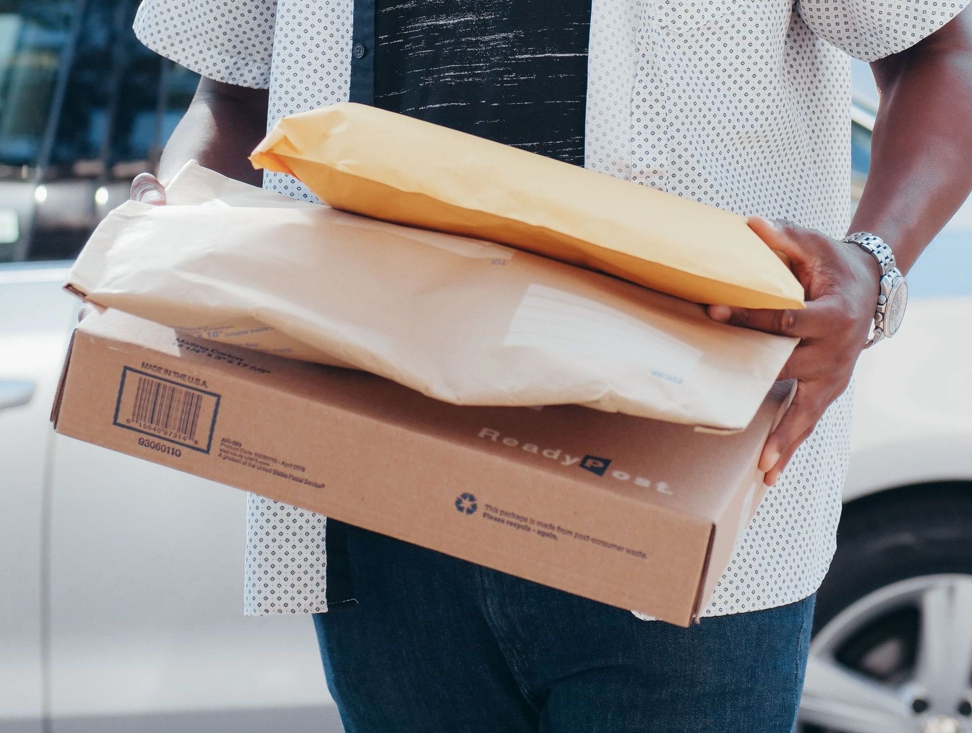 A deliveryman carrying packages outside, showcasing modern online shopping convenience.